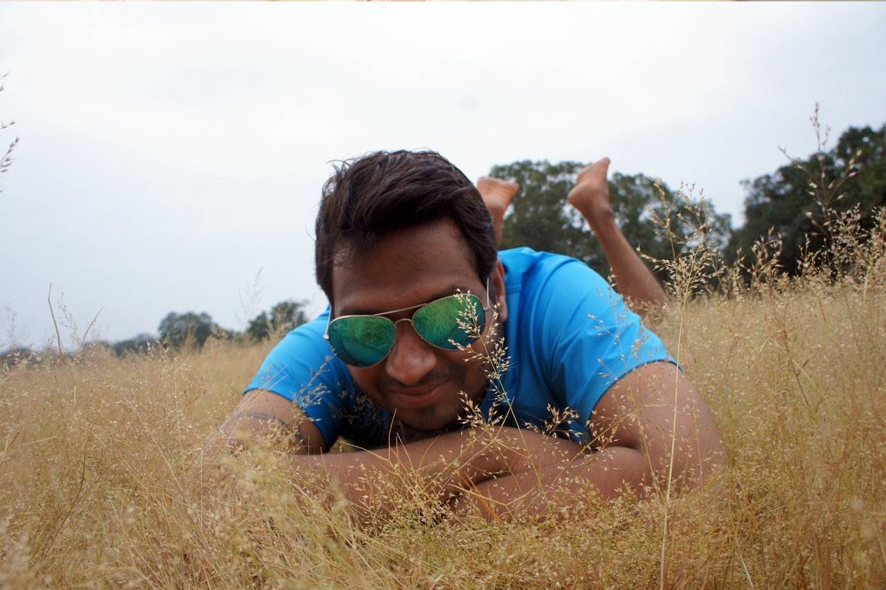 man in grass with sunglasses